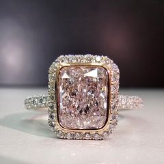 Pink diamond engagement ring surrounded by a white diamond halo