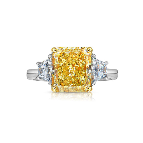 Old money 4 carat fancy yellow radiant set in 3 stone platinum ring.