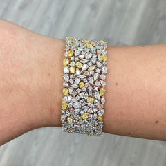 Luxurious multi-color diamond bracelet featuring pink, yellow, and white diamonds in a unique design.