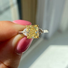 Elegant Fancy Yellow radiant cut diamond engagement ring with VS2 clarity and GIA certification.
