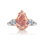 Unique three-stone ring with a deep brown-pink pear diamond and blue diamond accents, GIA certified.