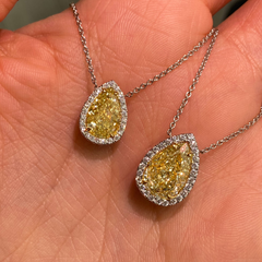 Pear shape yellow diamond with white halo diamonds and a VVS2 clarity.