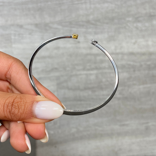 Light yellow radiant cut and F color heart shaped diamonds in a VS clarity white gold bezel cuff.