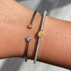 Light yellow radiant cut and F color heart shaped diamonds in a VS clarity white gold bezel cuff.