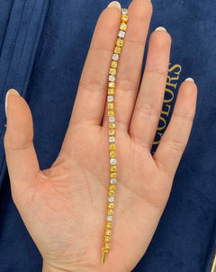 Fancy tennis bracelet with alternating yellow and white cushion cut diamonds.