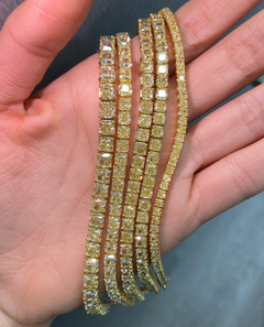 Elegant bracelet featuring fancy yellow cushion diamonds in a natural yellow diamond jewelry design with a VS - VVS clarity.