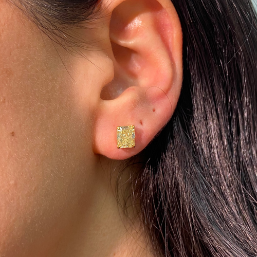 GIA certified fancy yellow diamond studs on ear