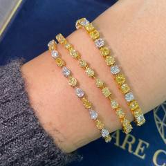 Fancy tennis bracelet with alternating yellow and white cushion cut diamonds.