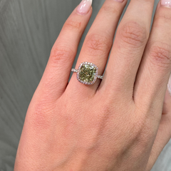 GIA certified greenish yellow cushion diamond in a pink halo engagement ring with VS1 clarity.