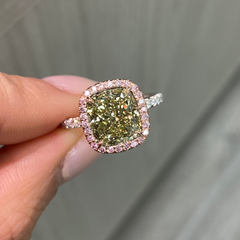 GIA certified greenish yellow cushion diamond in a pink halo engagement ring with VS1 clarity.
