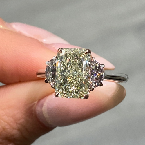 GIA-certified greenish yellow diamond ring with a radiant cut center stone and VVS2 clarity.