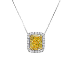Natural fancy light yellow cushion cut diamond in a white diamond halo on a 18k gold pendant.