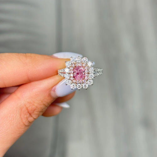 Fancy purplish pink radiant cut diamond ring with diamond halo.