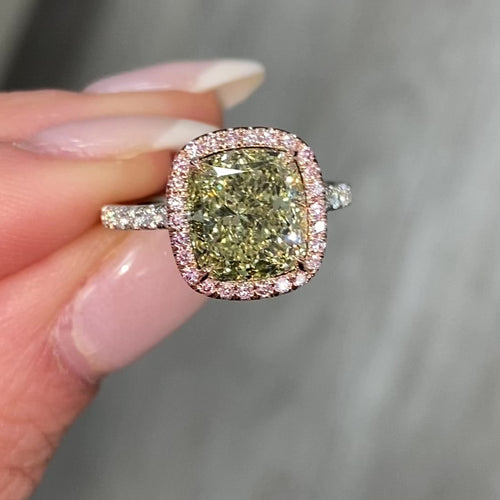 GIA certified greenish yellow cushion diamond in a pink halo engagement ring with VS1 clarity.
