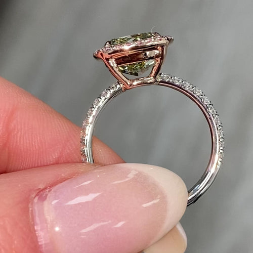 GIA certified greenish yellow cushion diamond in a pink halo engagement ring with VS1 clarity.