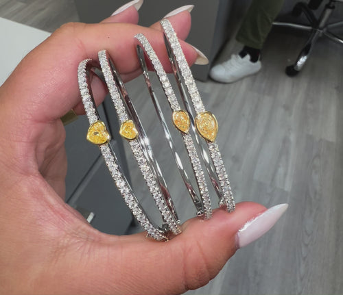 Unique heart shaped yellow diamond bangle with elongated white round diamonds and SI-VS1 clarity.