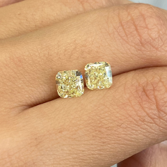 Unique matched pair of natural fancy light yellow cushion cut diamonds.