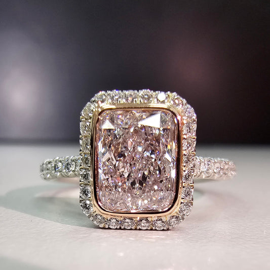 Pink diamond engagement ring surrounded by a white diamond halo 