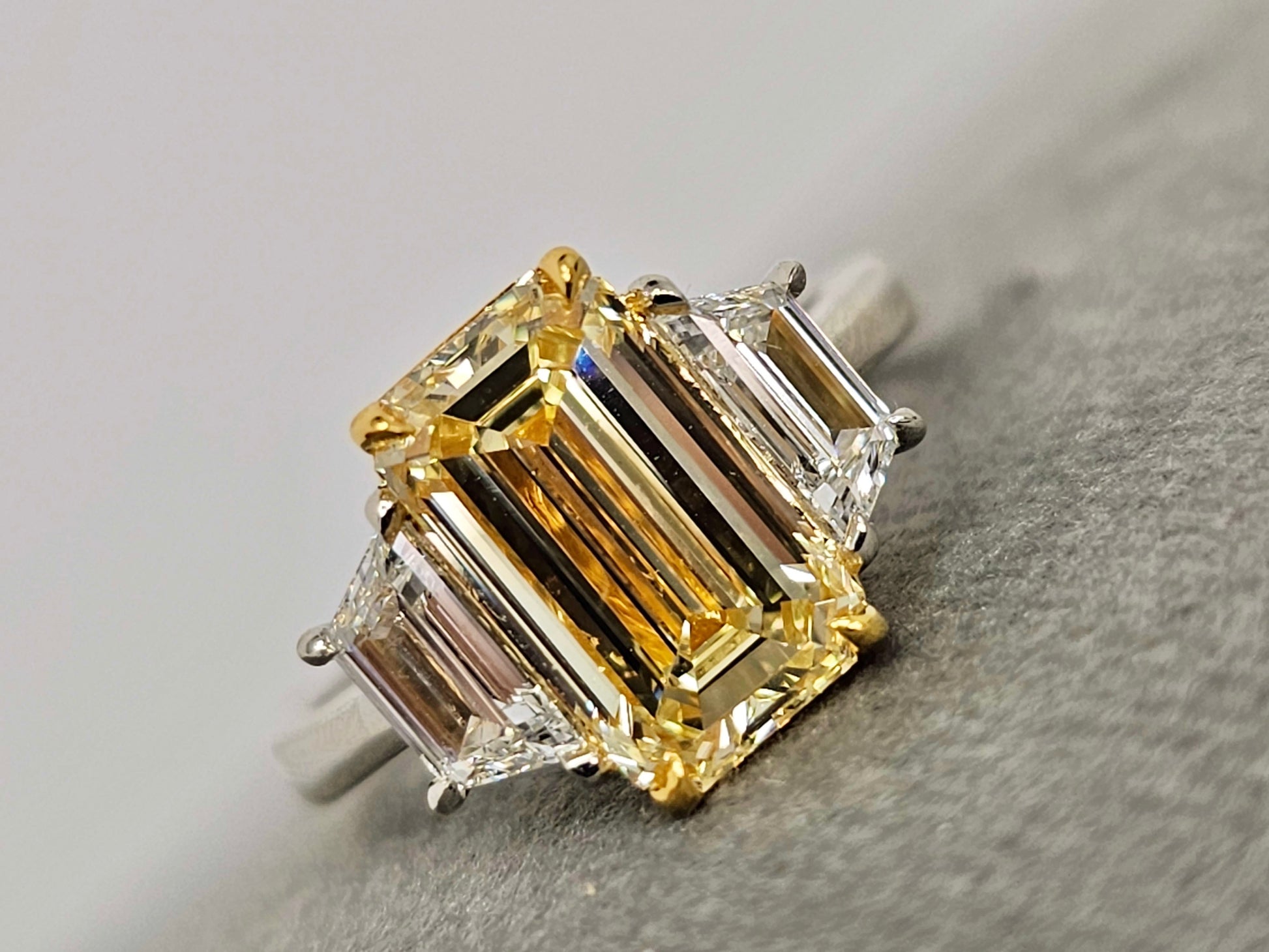 3 carat yellow diamond elongated emerald cut three stone ring with trapezoids
