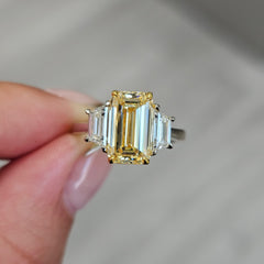 3 carat yellow diamond elongated emerald cut three stone ring with trapezoids