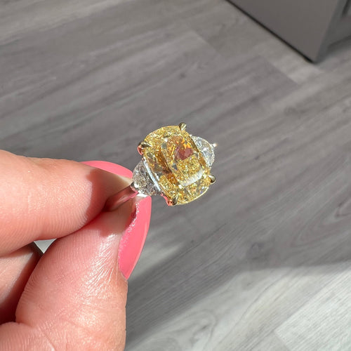 Fancy Yellow Diamond three stone ring. Elongated fancy yellow cushion