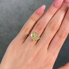 5 carat fancy light yellow elongated radiant cut diamond ring in yellow gold on female hand 