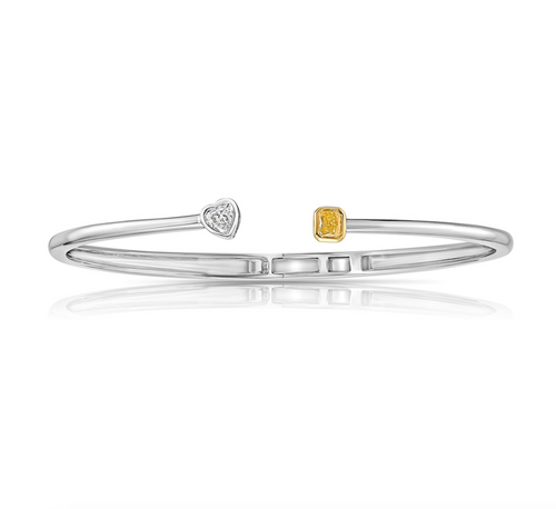 Light yellow radiant cut and F color heart shaped diamonds in a VS clarity  white gold bezel cuff.