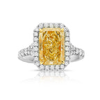 Elongated yellow diamond ring with white diamonds.