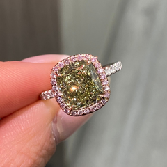 GIA certified greenish yellow cushion diamond in a pink halo engagement ring with VS1 clarity.