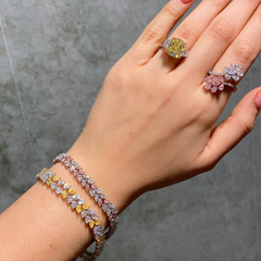 Hand wearing natural pink and yellow rings and jewelry