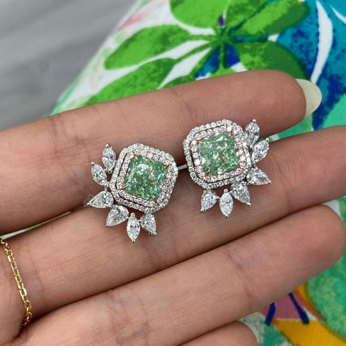 Unique green diamond stud earrings surrounded by natural pink and white diamond halos.