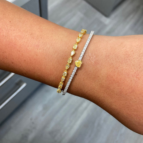 Fine heart shaped yellow diamond bangle with white round diamonds.