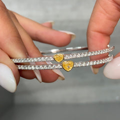 Fine heart shaped yellow diamond bangle with white round diamonds.