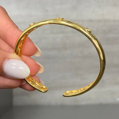 Unique bezel cuff bracelet with trio of yellow diamonds in radiant, oval, and pear shapes on a wide bangle.