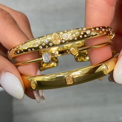 Unique bezel cuff bracelet with trio of yellow diamonds in radiant, oval, and pear shapes on a wide bangle.