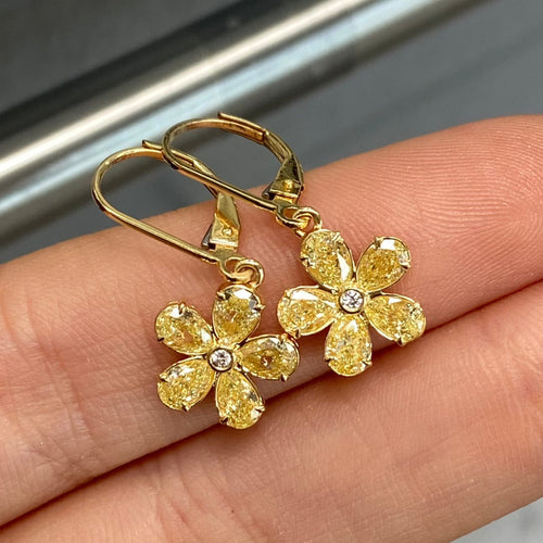 Unique flower shaped yellow diamond drop earrings with light yellow pear diamonds and round diamond center.