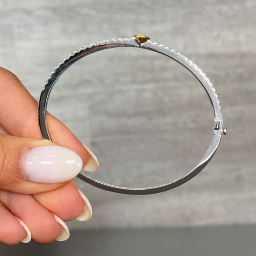 Fine heart shaped yellow diamond bangle with white round diamonds.