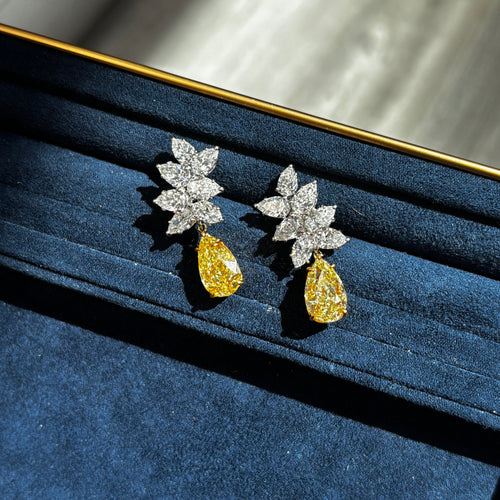 Fancy Light Yellow pear shape diamond earrings Natural yellow pear shape diamond cluster drop earrings with a total of 13.29 carats of natural white and yellow diamonds. Featuring 3 carat each, GIA Certified Fancy Light Yellow pear shape center diamonds with VS1 and VVS2 clarity.