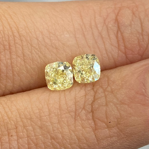 Matched pair yellow diamond rings with a soft yellow hue and elegant cushion cut.