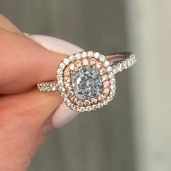 natural blue diamond ring, with blue cushion cut diamond surrounded by pink and white diamonds in a double halo ring design