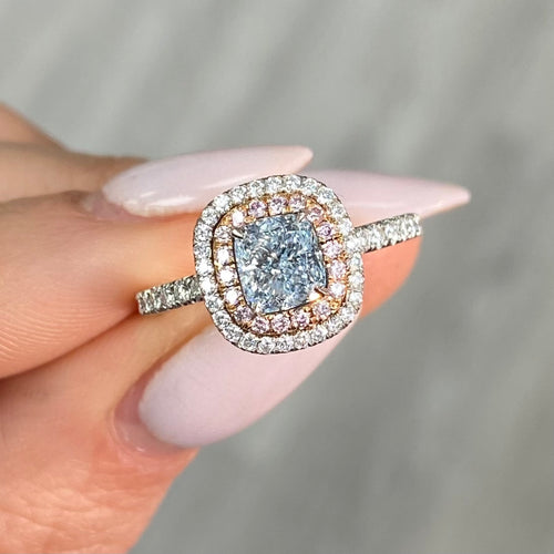 natural blue diamond ring, with blue cushion cut diamond surrounded by pink and white diamonds in a double halo ring design