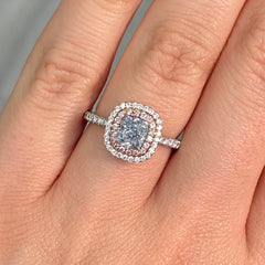 natural blue diamond ring, with blue cushion cut diamond surrounded by pink and white diamonds in a double halo ring design