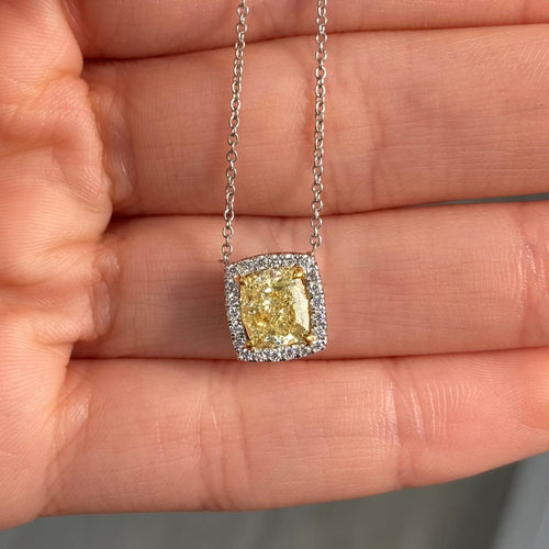 natural fancy light yellow cushion cut diamond in a white diamond halo on a 18k gold pendant