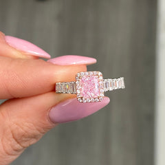 bubblegum pink diamond, pink radiant cut diamond surrounded by emerald cut and round diamonds, halo engagement ring with natural pink diamond