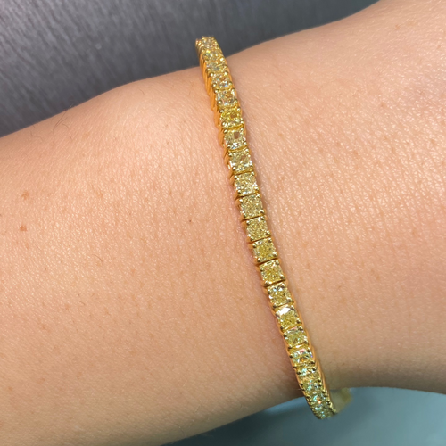 Elegant bracelet featuring fancy yellow cushion diamonds in a natural yellow diamond jewelry design with a VS - VVS clarity.