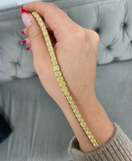 Fancy Yellow radiant cut diamond tennis bracelet with bezel-set diamonds in a sleek design with a SI and VS clarity.