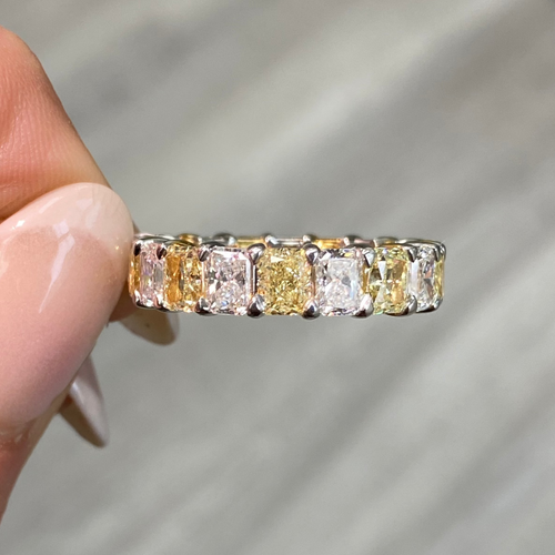 Elegant yellow and white radiant cut diamond eternity band featuring VS-VVS clarity.