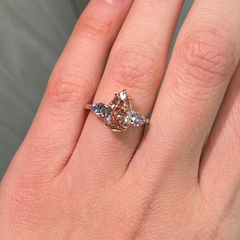 Unique three-stone ring with a deep brown-pink pear diamond and blue diamond accents, GIA certified.