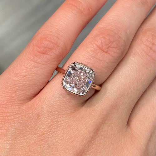 Elegant bezel set ring featuring a GIA certified very light pink cushion cut diamond.