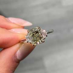 Natural green diamond engagement ring with a radiant cut center and yellow diamond accents.